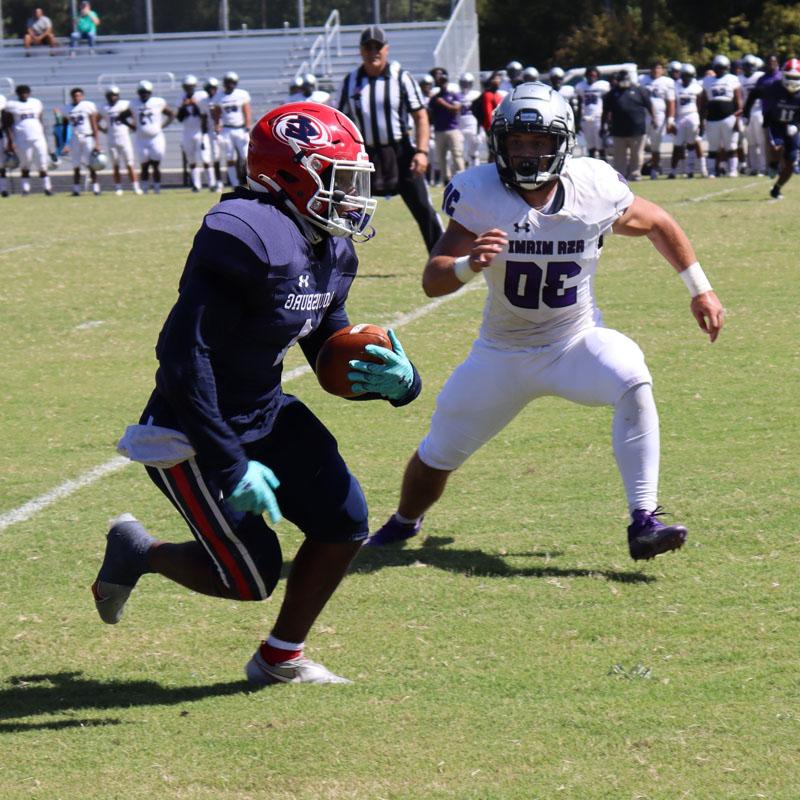 Football player carrying the ball in game action.